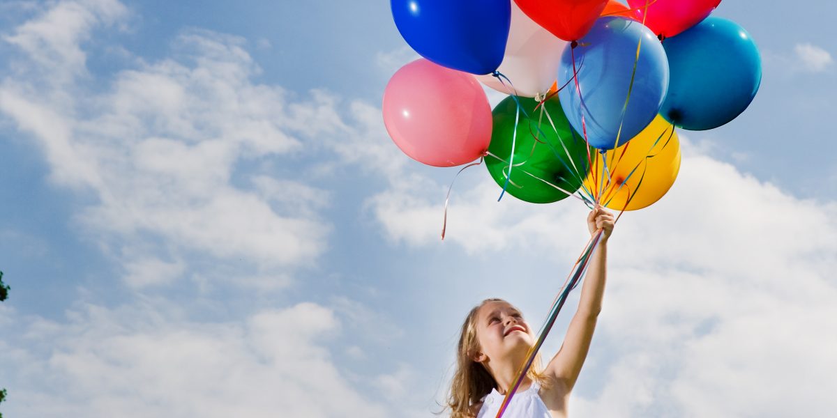 Girl holding a bunch of balloons