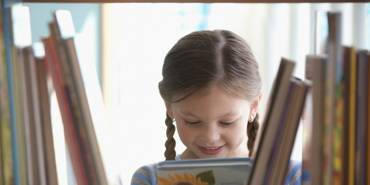 Little girl choosing a book to read